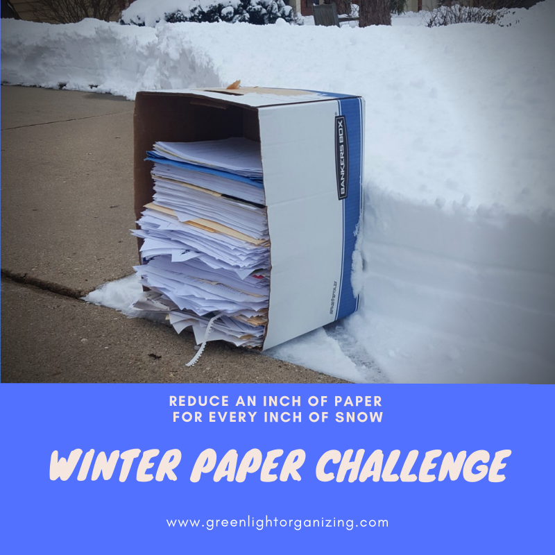 Box with a 12 inch stack of papers inside is propped up against a 12" snow pile. Photo text says, "Winter Paper Challenge. Reduce an inch of paper for every inch of snow."